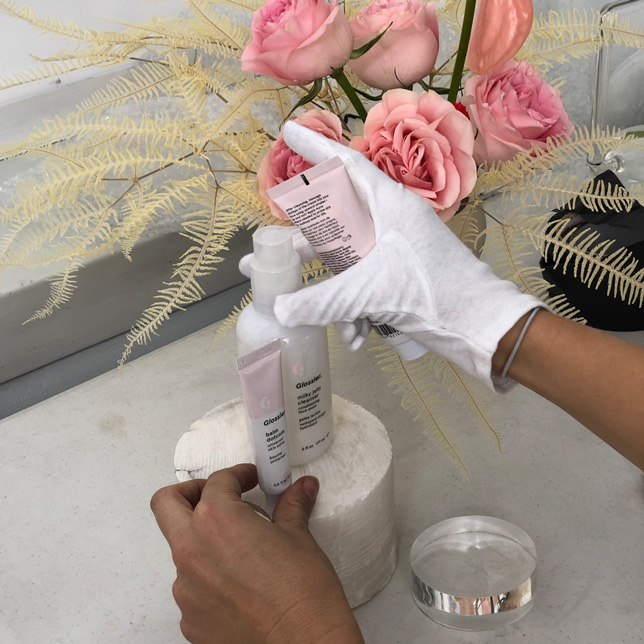 Various Glossier products and prop flowers that were used on set for the Glossier shoot